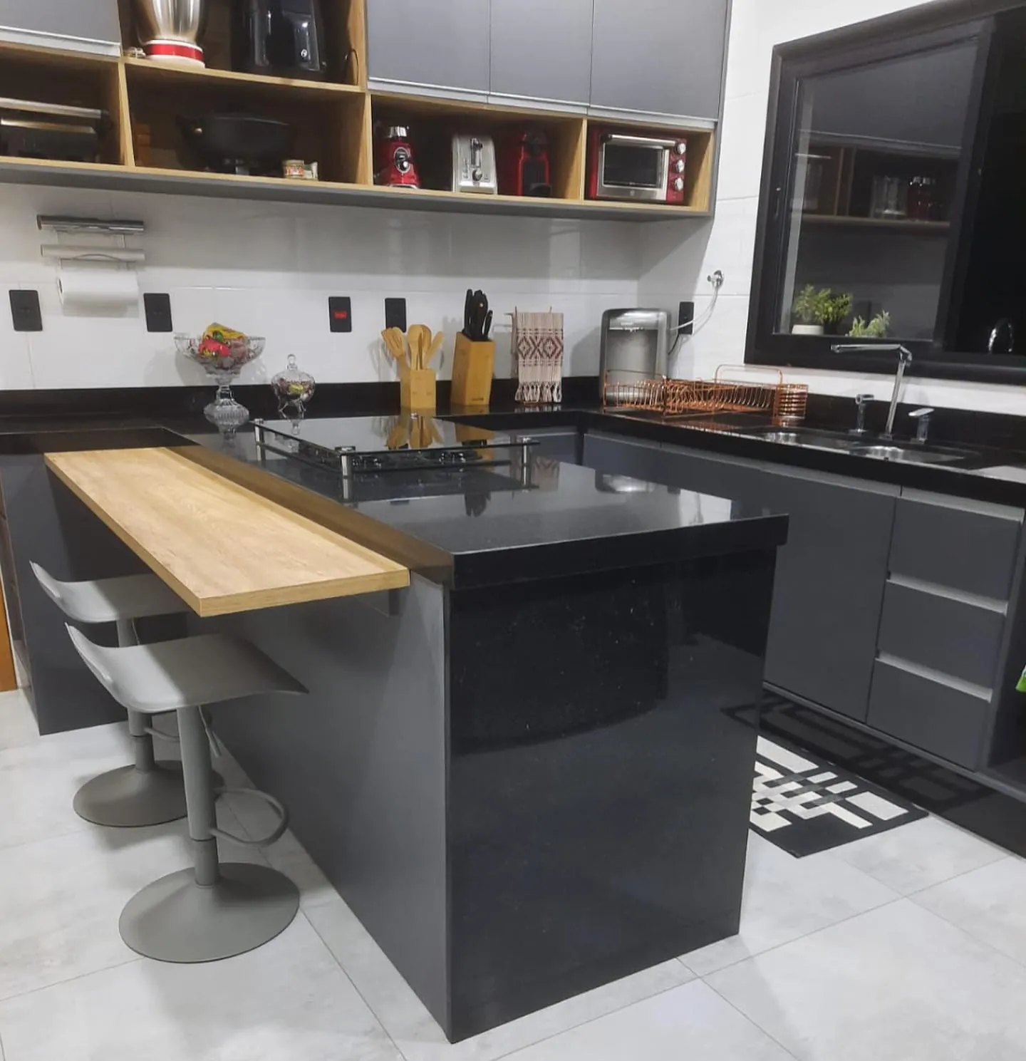 Cozinha com ilha e bancada em granito preto